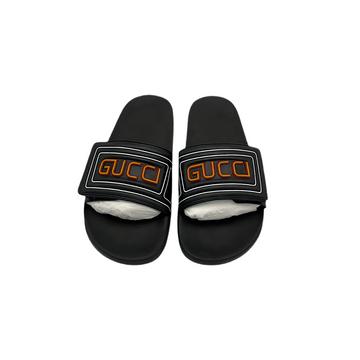 Front view of men's black Gucci slides with orange logo on a white background