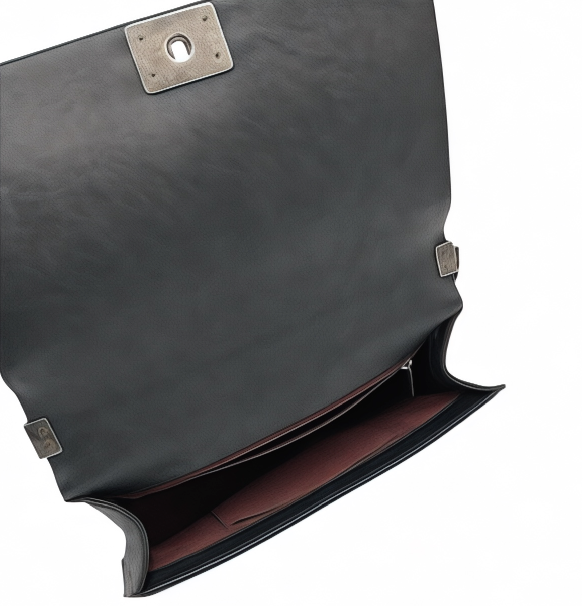 Inside look at a black leather Chanel Boy Bag with silver clasp on a white background
