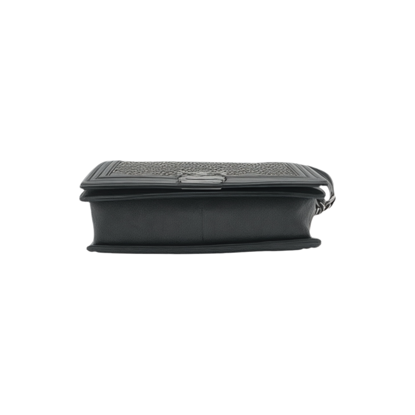 Bottom view of black medium Chanel Boy bag with silver grommets on a white background