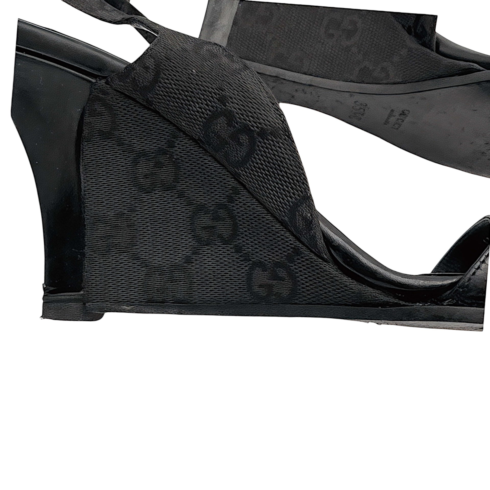 Side  view of heel on vintage Gucci black monogrammed wedge-heeled sandals on a white background